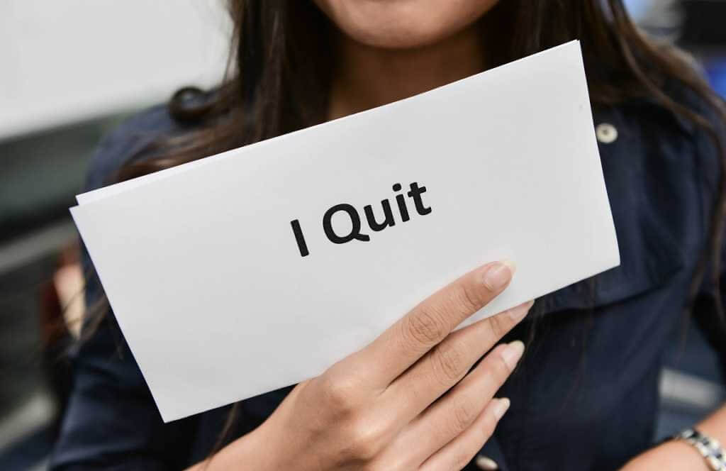woman holding up a sign that says I quit